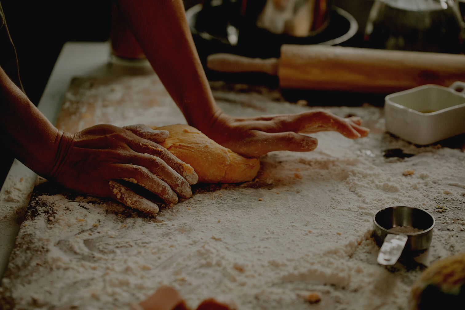 Woman making pastry on table with flour